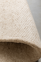 Close-up of a textured beige carpet corner. laine 100% naturelle tapis fais a la main naturug hand made rug morocco maroc marocain